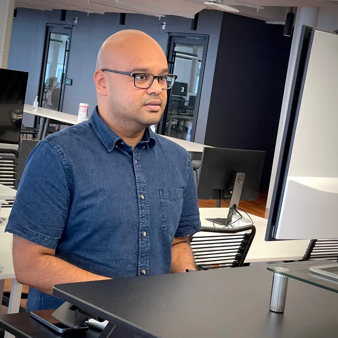 Sri Ray smiling at a desk