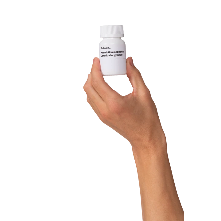 Hand holding white pill bottle